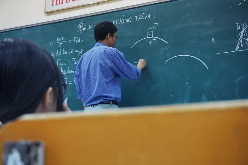 Преподаватель пишет формулы на доске